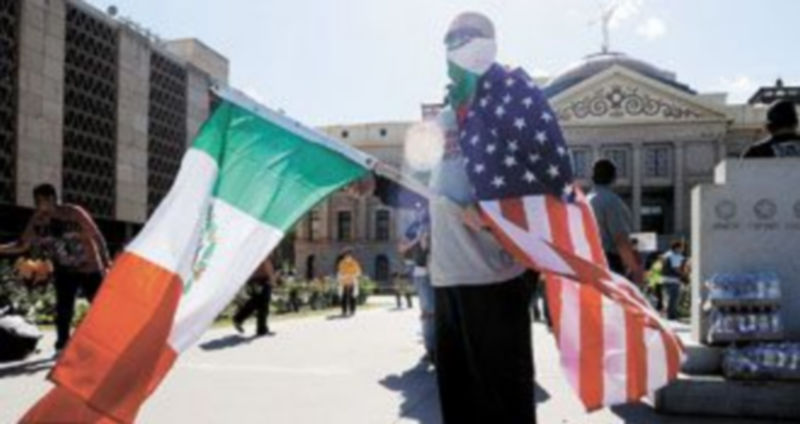 Un hombre con las banderas de EEUU y México protesta contra la nueva Ley de Inmigración de Arizona