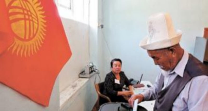 Un kirguís deposita su papeleta durante la jornada del referendo popular celebrado para someter a votación el nuevo texto constitucional