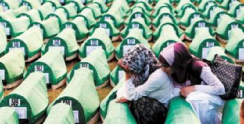 Dos mujeres lloran entre féretros durante el funeral por 775 víctimas de la matanza de Srebrenica recientemente identificadas