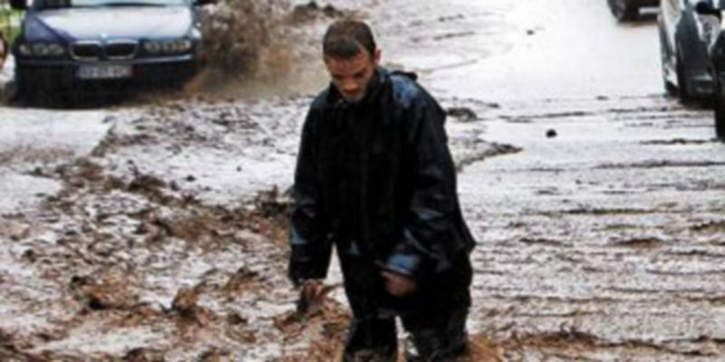 Un hombre intenta caminar en una calle de la zona baja de Funchal. / Reuters