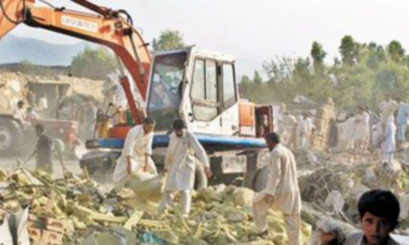 Varias personas desescombran el escenario del atentado suicida del viernes en Pakistán