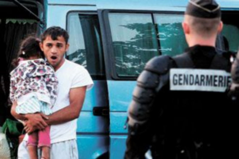 Un policía participa en la evacuación de un grupo de gitanos rumanos de un asentamiento irregular en la región francesa de Saint Martni d’Heres. / MARC GREINER (EFE)