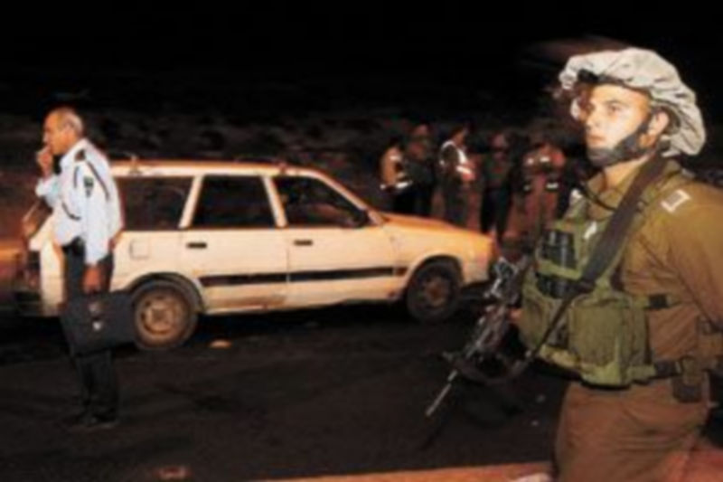 Un soldado israelí pasa junto al vehículo en el que ayer cuatro personas fueron tiroteadas mortalmente. / Ronen Zvulun (Reuters)