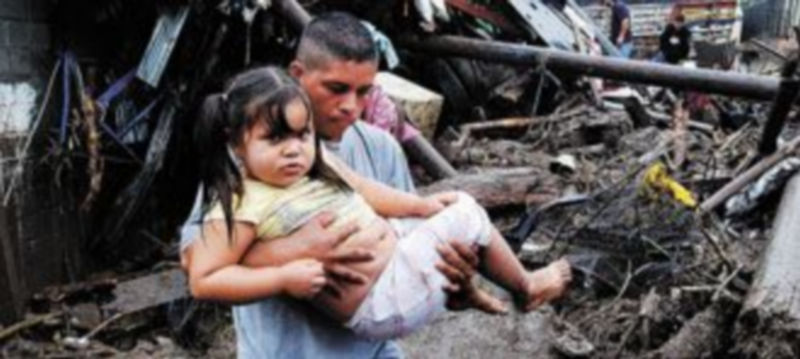 Un hombre saca a su hija de una casa en la localidad de Verapaz