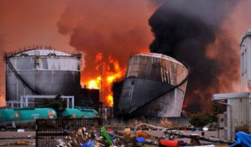 Una columna de llamas y humo emerge de una planta de refinería de petróleo próxima a una central térmica en Shiogama