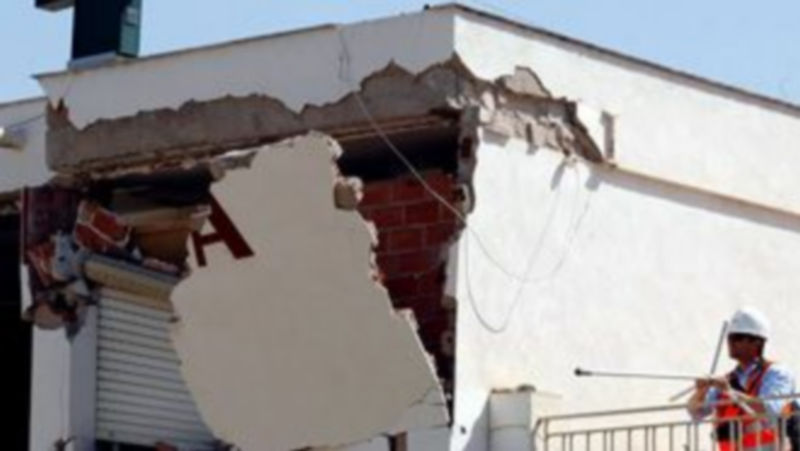 Los técnicos derriban la pared de un edificio afectado por los terremotos