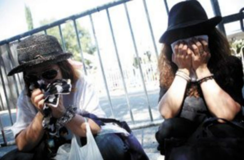 Dos admiradoras de Michael Jackson lloran la muerte del artista frente a la casa familiar de éste en Encino
