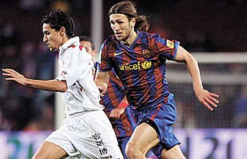 El barcelonista Chigrinsky intenta detener el avance del jugador del Sevilla Jesús Navas. / EFE