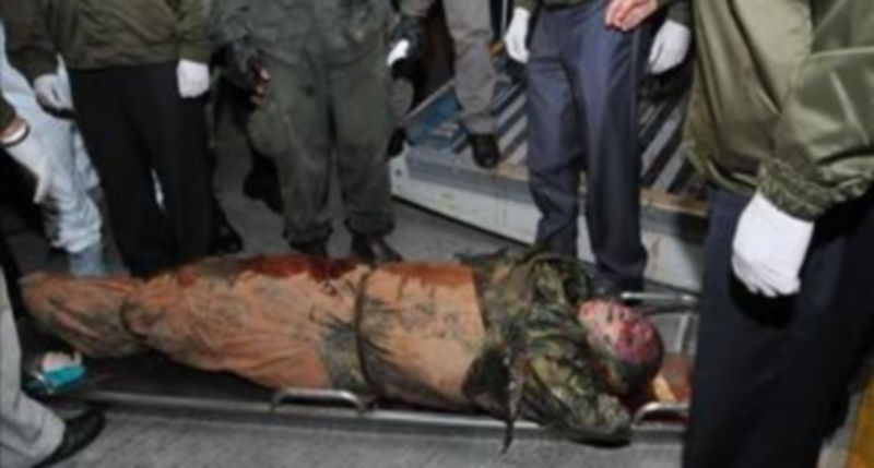 Miembros de la policía bajan de una aeronave el cuerpo del abatido líder de las Fuerzas Armadas Revolucionarias de Colombia (FARC)