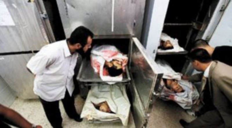 Varios palestinos observan los cadáveres de cuatro milicianos muertos ayer en un ataque israelí a la costa de Gaza. / Mohammed Saber (Efe)