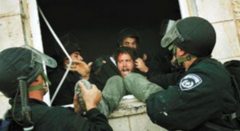 Varios policías israelíes desalojan a un colono hebreo de un asentamiento ilegal en Cisjordania. / Efe