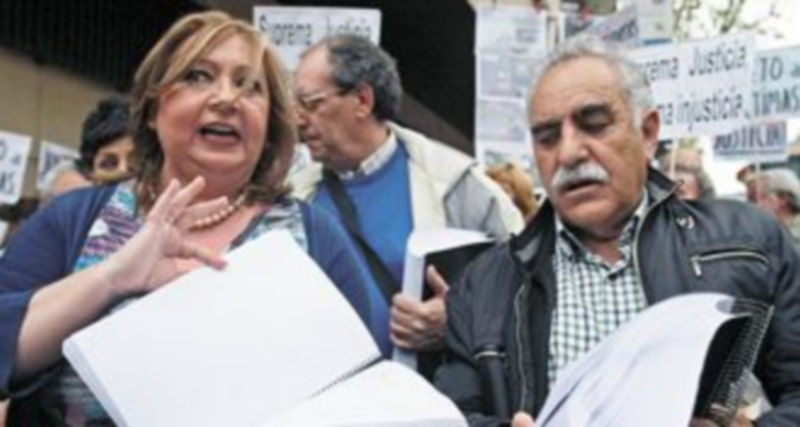 Representantes de las asociaciones para la recuperación de la Memoria muestran las firmas recogidas en apoyo a Garzón. / Efe