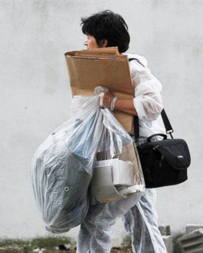 Una agente de Policía traslada evidencias recogidas en el piso de un etarra. / EFE