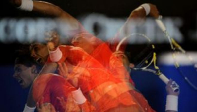 Imagen de exposición mútiple que muestra al tenista español Rafael Nadal mientras sirve sobre el australiano Bernard Tomic durante su partido de tercera ronda del Abierto de Australia de tenis.