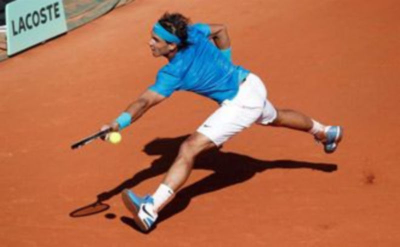 El tenista español Rafael Nadal devuelve la bola al sueco Robin Soderling durante su partido de cuartos de final ./ EFE