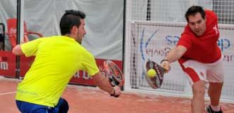 Un participante en la tercera jornada del Circuito Provincial de Pádel se anticipa a su compañero y golpea la pelota con su raqueta. / Kamarero