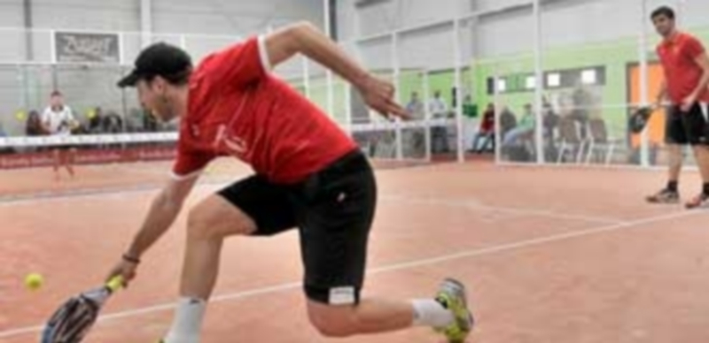 Uno de los jugadores se agacha para golpear una bola baja