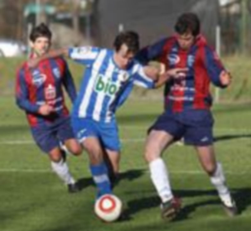 Un jugador de la Ponferradina B intenta escaparse de la defensa del gimnástico Anel