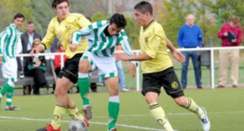 Un jugador del Betis intenta darle una salida al balón entre dos rivales del Quintanar. / Kamarero