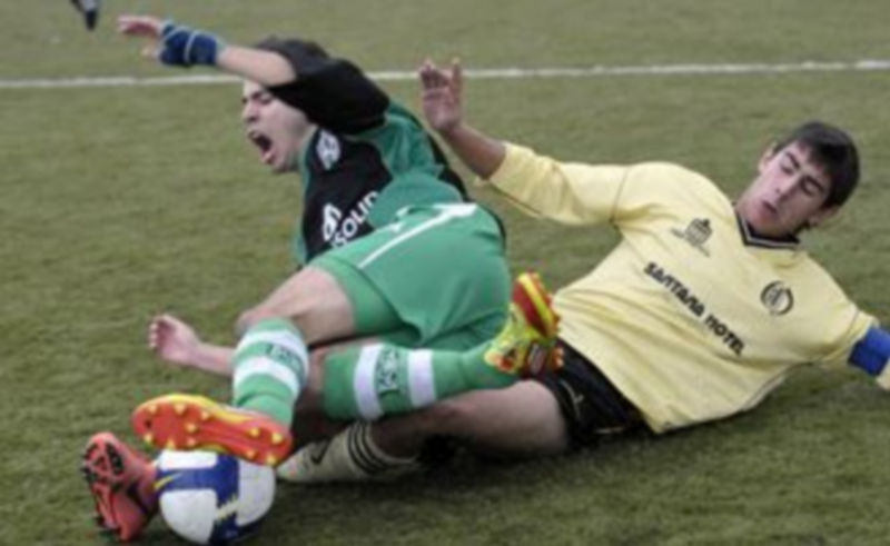 Un jugador del Quintanar se emplea en defensa ante un rival del Víctoria