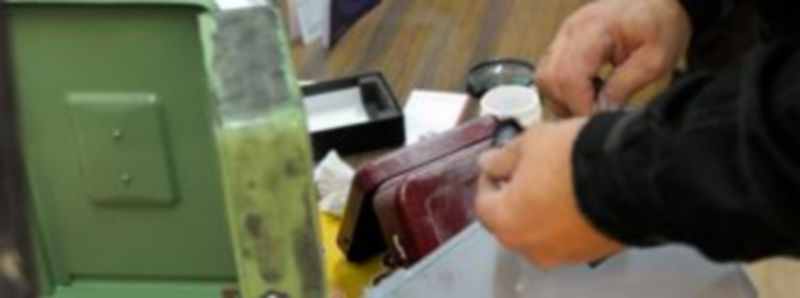 Un policía toma huellas en la sede de los sindicatos./ KAMARERO