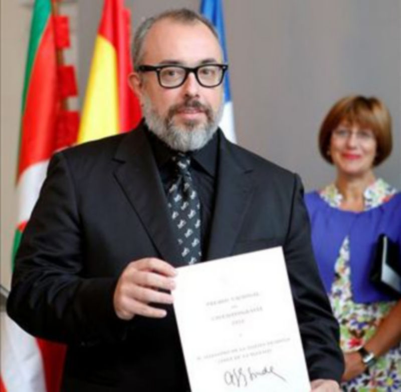 El realizador Alex de la Iglesia (i) muestra el Premio Nacional de Cinematografía 2010 que recogió en el marco de la 58 edición del Festival Internacional de Cine de San Sebastián./EFE