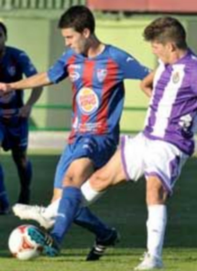 Manu intenta controlar el balón ante la oposición de un rival del Valladolid B. / Juan Martín