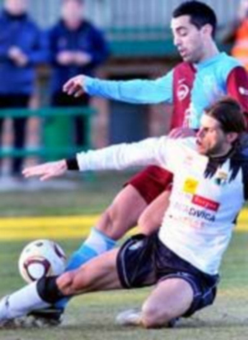 Pino se encuentra con la oposición de un jugador burgalés en el encuentro de ida jugado en La Albuera. / Kamarero