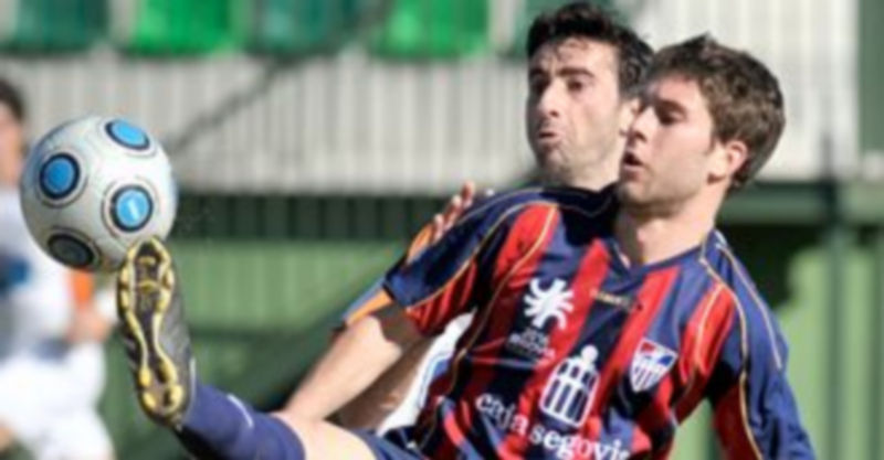 Manu controla el balón con un defensor del Almazán marcándole de cerca en la imagen correspondiente al partido de la pasada temporada. / Kamarero