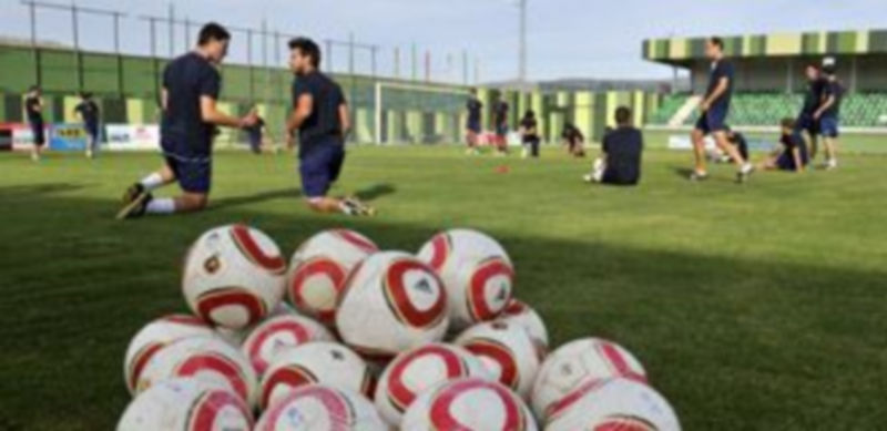 La plantilla efectúa ejercicios de estiramientos al fondo