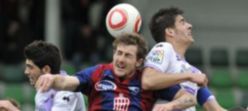 Dani trata de tocar el balón con la cabeza ante la oposición de dos defensores del Numancia B. / Juan Martín