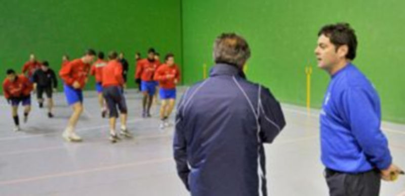Paco Maroto y Jesús Bellota dialogan mientras los jugadores entrenan en el Frontón Segovia. / Kamarero