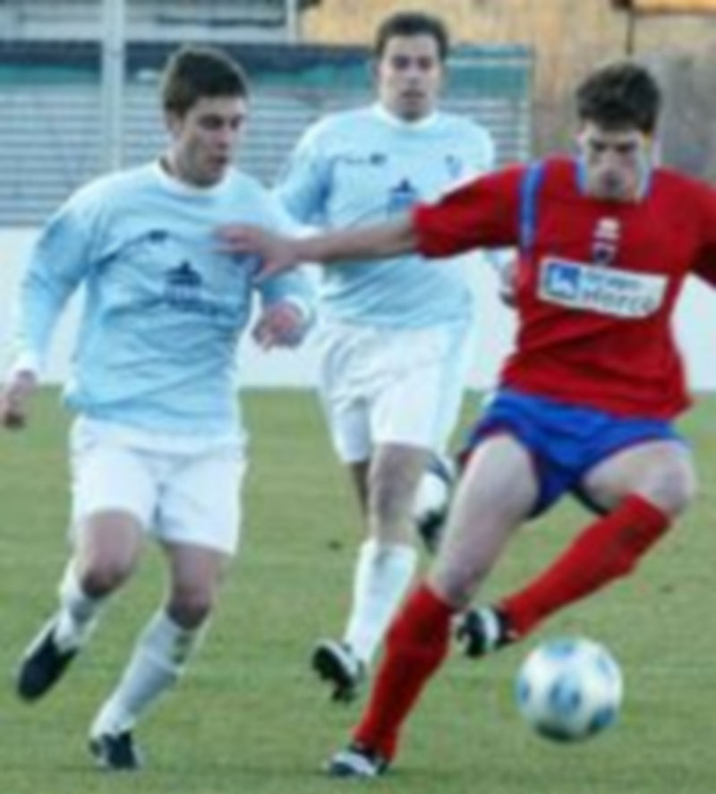 Rubén persigue a un jugador del Numancia B ante la mirada de Chus. /Heraldo de Soria