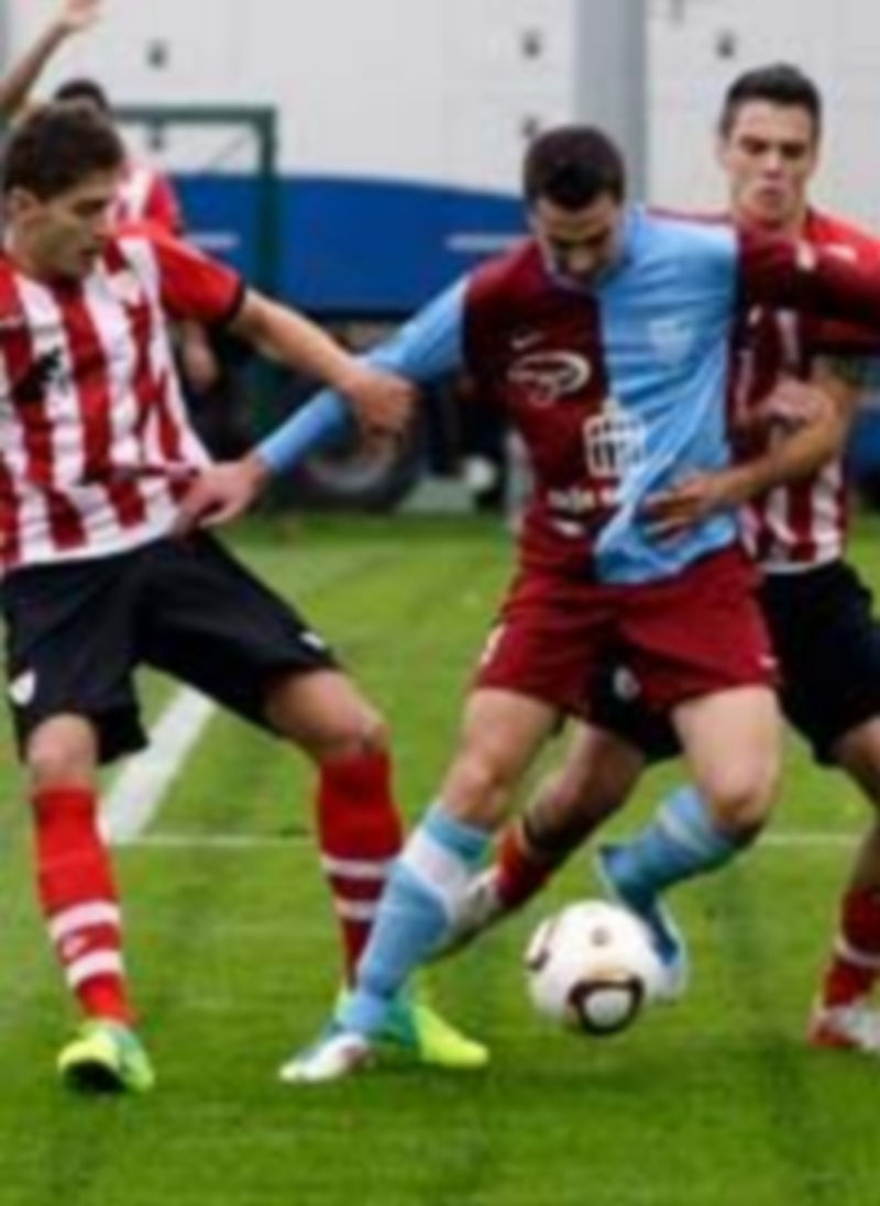 Fran Dorado trata de controlar la pelota ante dos adversarios del Athletic B durante el partido de ida. / El Adelantado