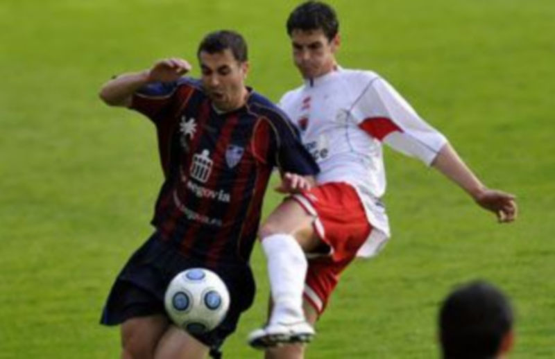 El gimnástico Fran disputa un balón con un rival del Numancia B durante un encuentro anterior en el campo de La Albuera. / Juan Martín