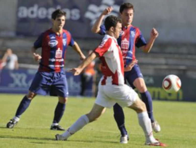 Un jugador de la SD Logroñés intenta salir con el balón controlado ante la defensa del segoviano Víctor Pérez. / Juan Martín.