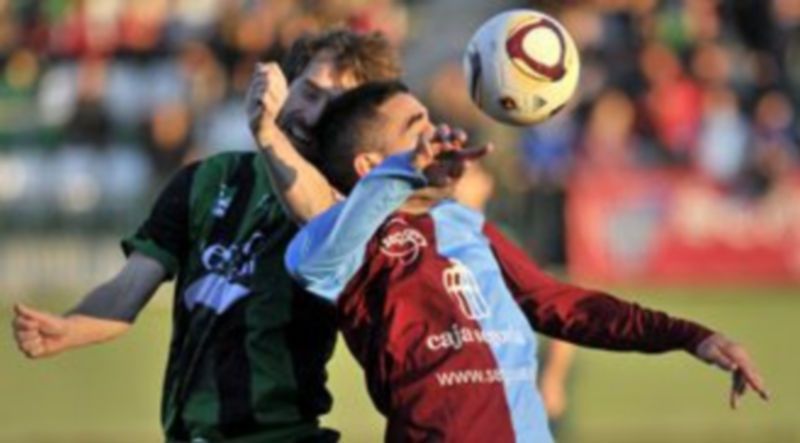 Dos rivales con poco que jugarse 1 Pino trata de controlar una pelota con la cabeza ante la presión de un jugador contrario. / Juan Martín