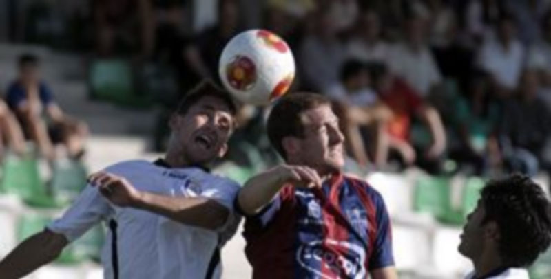 Dani Arribas intenta llegar a un balón aéreo ante la oposición de un defensor abulense. / Juan Martín