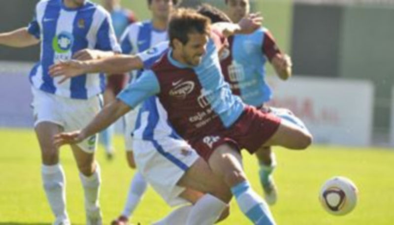 Maikel recibe la entrada de un oponente durante el encuentro que la Segoviana jugó ante la Real B. / Juan Martín