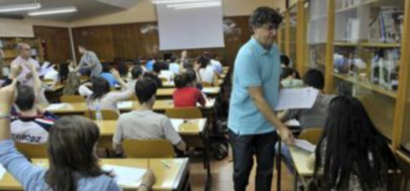 Un profesor reparte exámenes en el IES Andrés Laguna. / KAMARERO