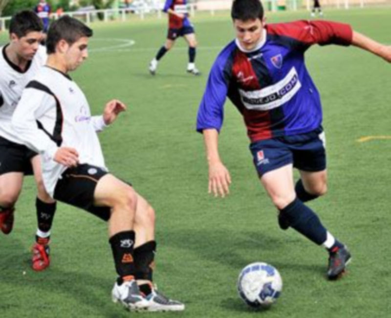 Un juvenil gimnástico intenta escaparse de un rival salmantino. /KAMARERO