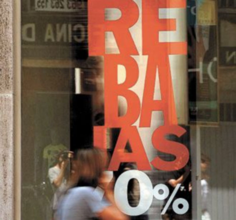 Una mujer pasa delante de una tienda con el cartel de rebajas. / Kai Försterling (Efe)