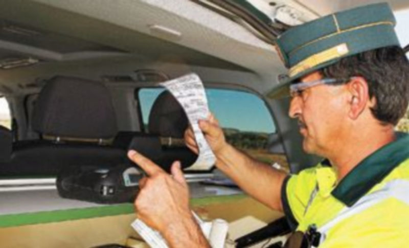 Un agente de la Guardia Civil comprueba los datos de la denuncia por exceso de velocidad a un vehículo. / Gustavo Cuevas (Efe)