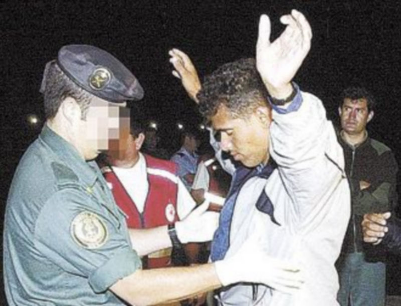 Un guardia civil cachea a un inmigrante. / T. A.