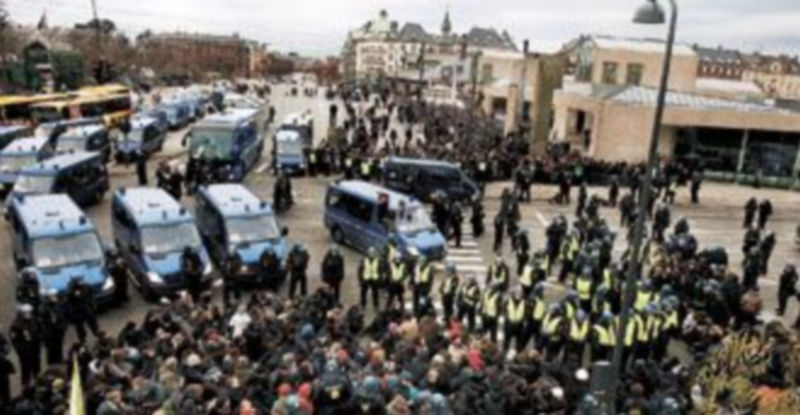 Decenas de antidisturbios rodean a un grupo de activistas durante una marcha en el puerto de Copenhague enmarcada en las protestas que acompañan a la cumbre. / Efe