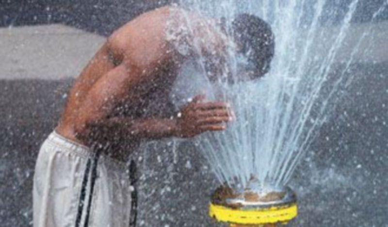 Un joven aprovecha el agua para refrescarse mientras continúa la ola de calor africana