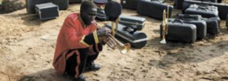 Un joven ensaya con una trompeta antes de participar en los actos con motivo del nuevo estatus del país. / Efe