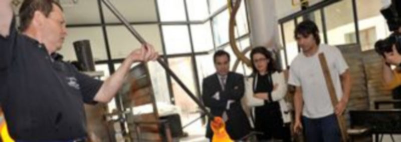 El maestro vidriero Juan Manuel Ramos deposita sobre el molde el cristal fundido que tomará la forma de una raqueta./Kamarero