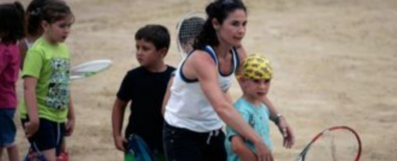 Virginia Ruano enseña a uno de los niños a ejecutar un golpe. / A.Bartolomé