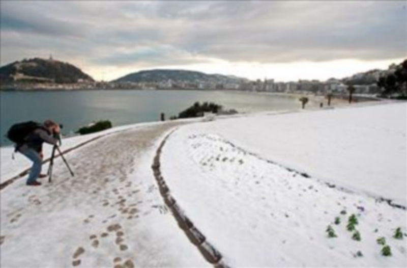 Un joven toma fotografías desde los jardines del Palacio de Miramar